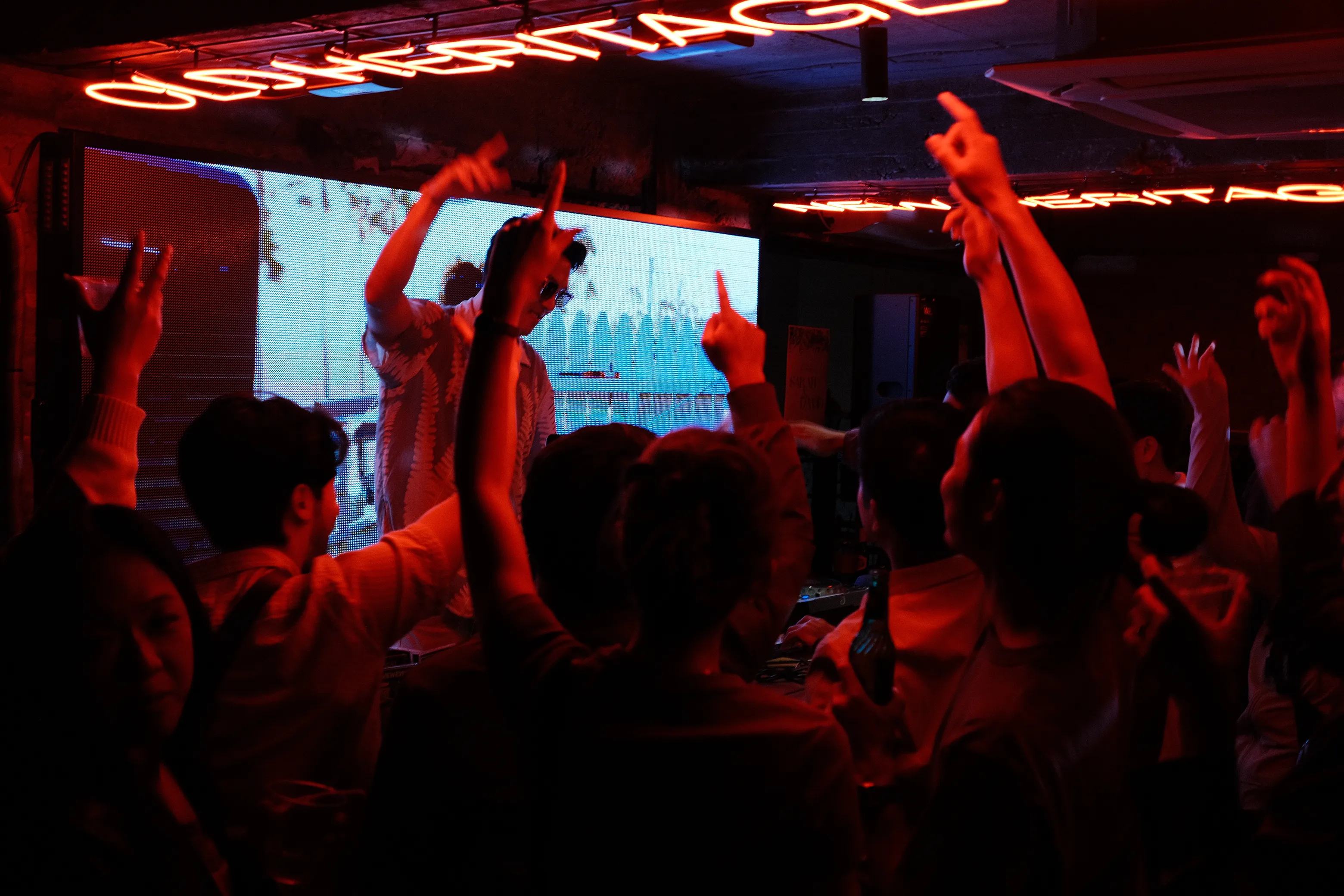 DJ performing at a nightclub with energetic crowd